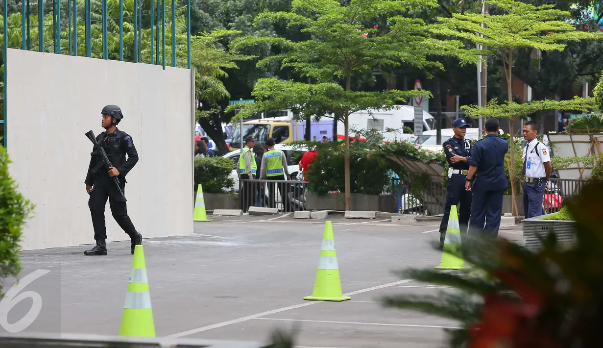 Seorang petugas kepolisian bersenjata terlihat berjaga di sekitar Menara Cakrawala, Jakarta, Sabtu (16/1). Pasca ledakan di Jalan MH Thamrin pada Kamis (14/1) lalu, petugas keamanan menutup rapat pintu masuk gedung tersebut. (Liputan6.com/Faizal Fanani)