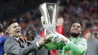 Kiper MU, Sergio Romero (kanan) mengangkat trofi Liga Europa, Swedia, Kamis (25/5). MU keluar sebagai juara Liga Europa setelah mengalahkan Ajax Amsterdam 2-0 di Friends Arena, Stockholm. (AP Photo)
