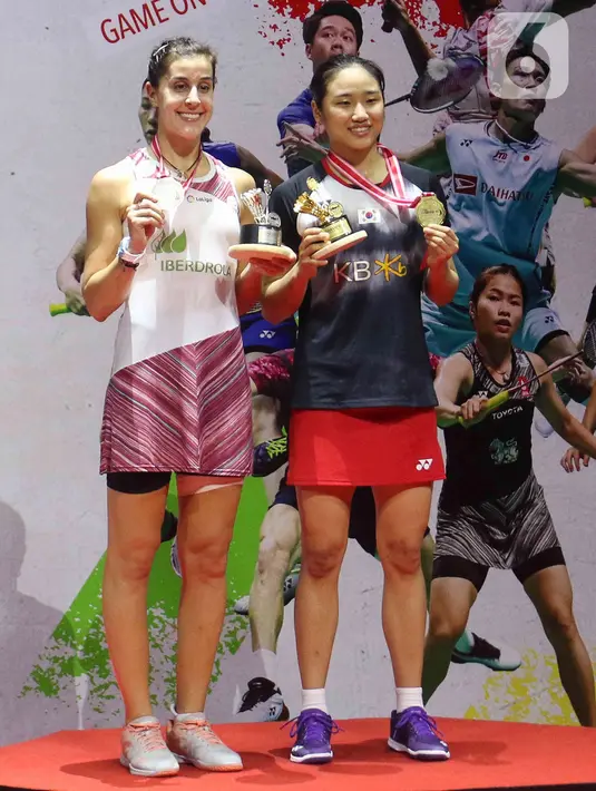 Pebulu tangkis tunggal putri Korea Selatan, An Se Young (kanan) bersama Carolina Marin dari Spanyol berpose dengan trofi usai laga final Indonesia Masters 2023 di Istora Senayan, Jakarta, Minggu (29/1/2023). An Se Young berhasil menjadi juara di nomor tunggal putri Indonesia Masters 2023 usai mengalahkan Carolina Marin di final dengan skor 18-21, 21-18, dan 21-13. (Liputan6.com/Herman Zakharia)