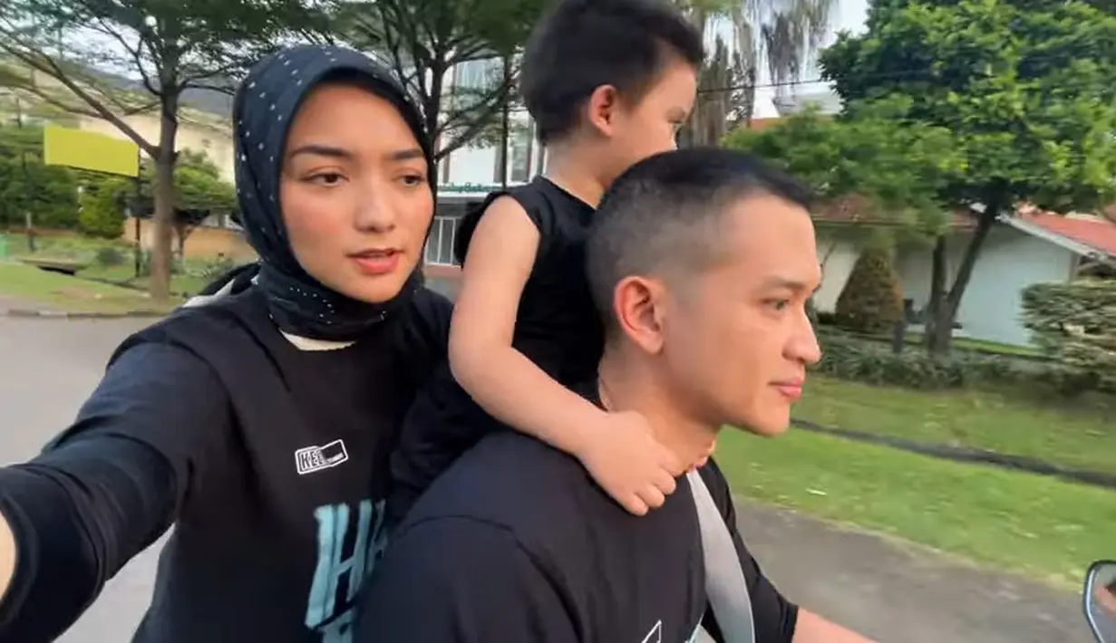Dengan mengendarai motor matik, pasangan ini terlihat keliling-keliling. Athar tampak berdiri ditengah sambil melihat-lihat. [Youtube/Ciky Citra Rezky]
