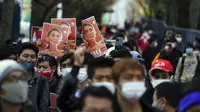 Warga Myanmar yang tinggal di Jepang membawa foto pemimpin Myanmar Aung San Suu Kyi yang kini ditahan saat protes di depan Kementerian Luar Negeri di Tokyo (3/2/2021). Militer Myanmar melakukan kudeta dan Senin 1 Februari dan menahan sejumlah tokoh termasuk Aung San Suu Kyi. (AP Photo/Eugene Hoshiko