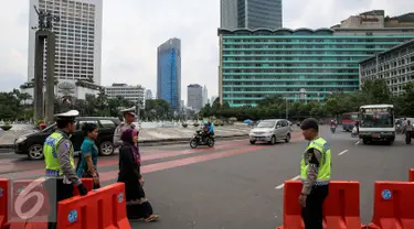 Petugas menutup jalan yang mengarah ke Sarinah, Jakarta, Kamis (14/1/2016). Paska teror bom dan penembakan di Sarinah, ruas jalan thamrin lengang. (Liputan6.com/Faizal Fanani)