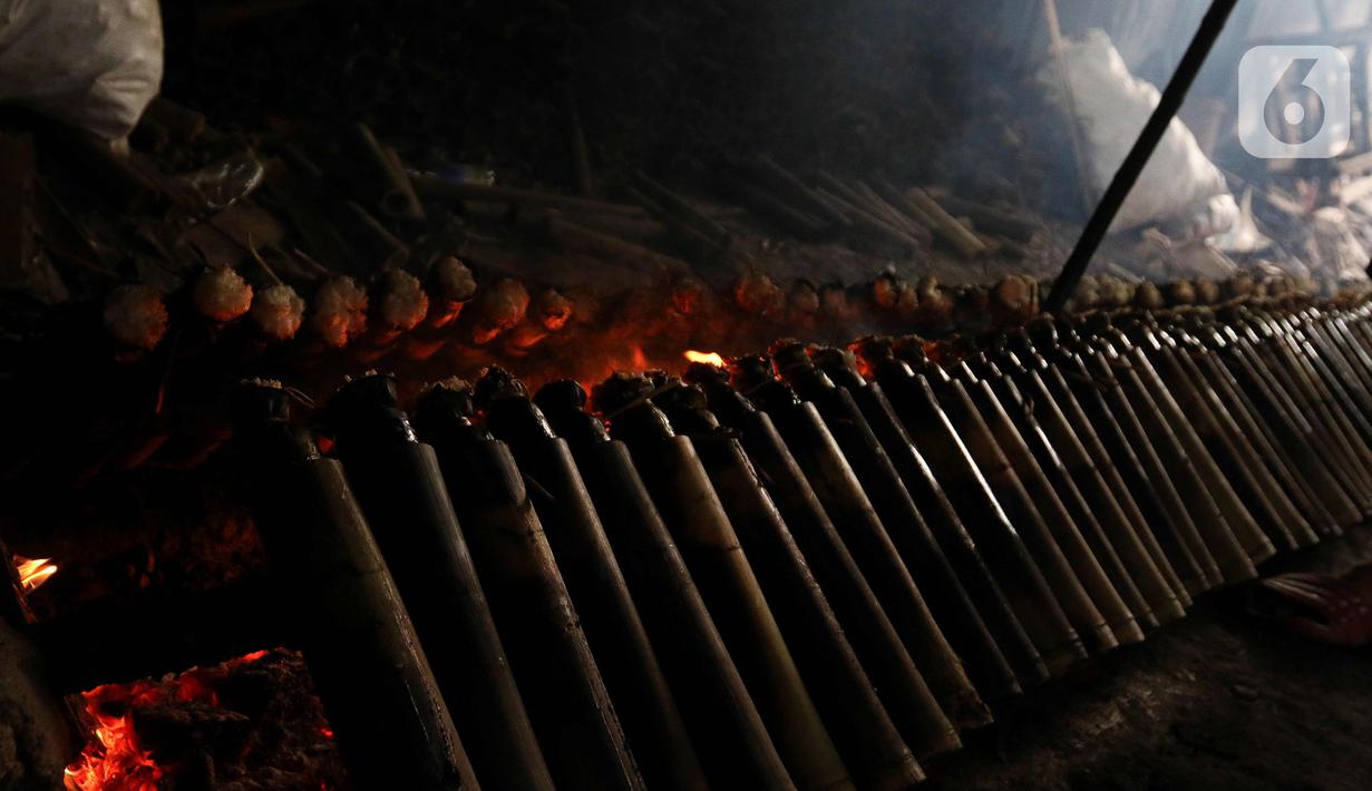 Pekerja menjaga perapi lemang bambu agar dapat masak dengan sempurna dan rasanya enak. (Liputan6.com/Herman Zakharia)