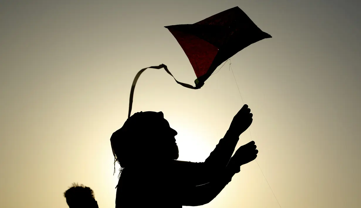 Seorang wanita saat menerbangkan layang-layang di festival layang-layang tahunan di Baghdad, Irak (5/6/2021). Festival layang-layang diadakan menarik ratusan penduduk setempat untuk menerbangkan layang-layang. (Xinhua/Khalil Dawood)