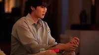 Moon Seo Ha menatap ke suatu tempat dengan ekspresi melankolis. Apakah Moon Seo Ha yang hidup dengan luka di hatinya dapat mengenali cinta pertamanya yang bereinkarnasi sebagai Ban Ji Eum? (Foto: tvN via Soompi)