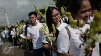 Gemabudhi membawa bunga yang akan dibagikan kepada pengguna jalan di depan Istana Negara, Jakarta, Sabtu (6/1). Aksi membagikan bunga sebanyak 2.561 tangkai itu dilakukan dalam rangka memperingati Hari Raya Trisuci Waisak. (Liputan6.com/Immanuel Antonius)