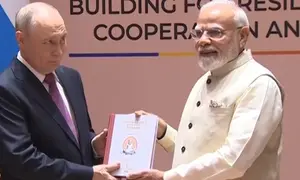 PM India Narendra Modi menghadiahkan terjemahan bahasa Rusia dari karya klasik Tamil kuno, Thirukkural, kepada Presiden Rusia Vladimir Putin saat keduanya bertemu di sela-sela KTT BRICS di New Delhi, Jumat (11/9/2026). (Dok. Tangkapan layar video AP)