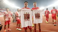 Dua pemain Timnas Indonesia, Justin Hubner (kiri) dan Ivar Jenner memegang jersey pemberian fans bergambar foto keduanya bersama rekannya, mendiang Noah Gesser setelah berakhirnya laga Grup F putaran kedua Kualifikasi Piala Dunia 2026 zona Asia menghadapi Irak di Stadion Utama Gelora Bung Karno (SUGBK), Senayan, Jakarta, Kamis (6/6/2024). (Bola.com/M Iqbal Ichsan)