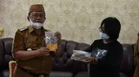 Bupati Gorontalo Utara, Indra Yasin bersama Arkeolog asal Sulawesi Utara menunjukan koin Emas yang ditemukan di Benteng Mass (Arfandi Ibrahim/Liputan6.com)