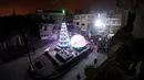Suasana perayaan malam Natal di kawasan Al-Hamidiyah yang dikelilingi reruntuhan bangunan kota tua Homs, Suriah, (24/12). (REUTERS/Omar Sanadiki)