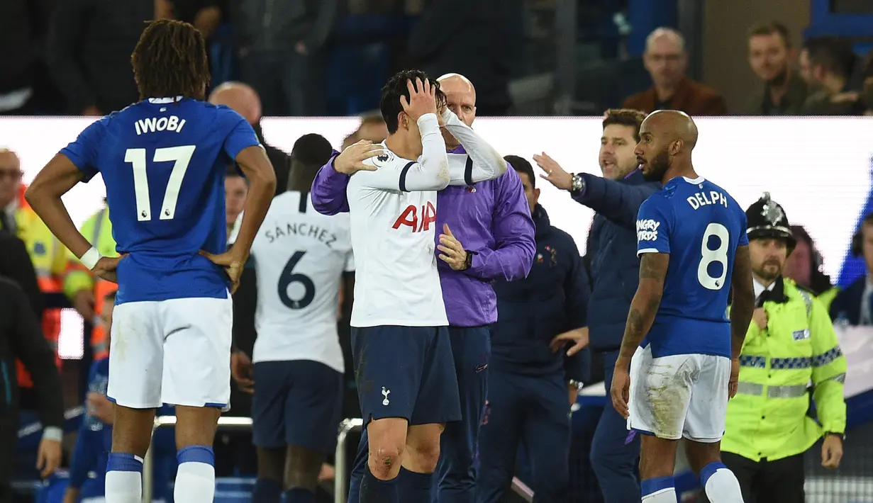 Striker Tottenham Hotspur Son Heung-min (tengah) memegangi kepalanya setelah menekel gelandang Everton Andre Gomes pada pertandingan Liga Inggris di Goodison Park, Liverpool, Inggris, Minggu (3/11/2019). Tekel Son Heung-min menyebabkan Andre Gomes patah kaki. (Oli SCARFF/AFP)