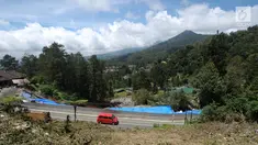 Kendaraan melintasi di sekitar area yang longsor di kawasan Ciloto, Cianjur, Jawa Barat, Sabtu (31/3). Longsor yang terjadi pada Rabu (28/3) lalu diduga adanya pergerakan tanah sehingga menyebabkan longsor. (Liputan6.com/Helmi Fithriansyah)