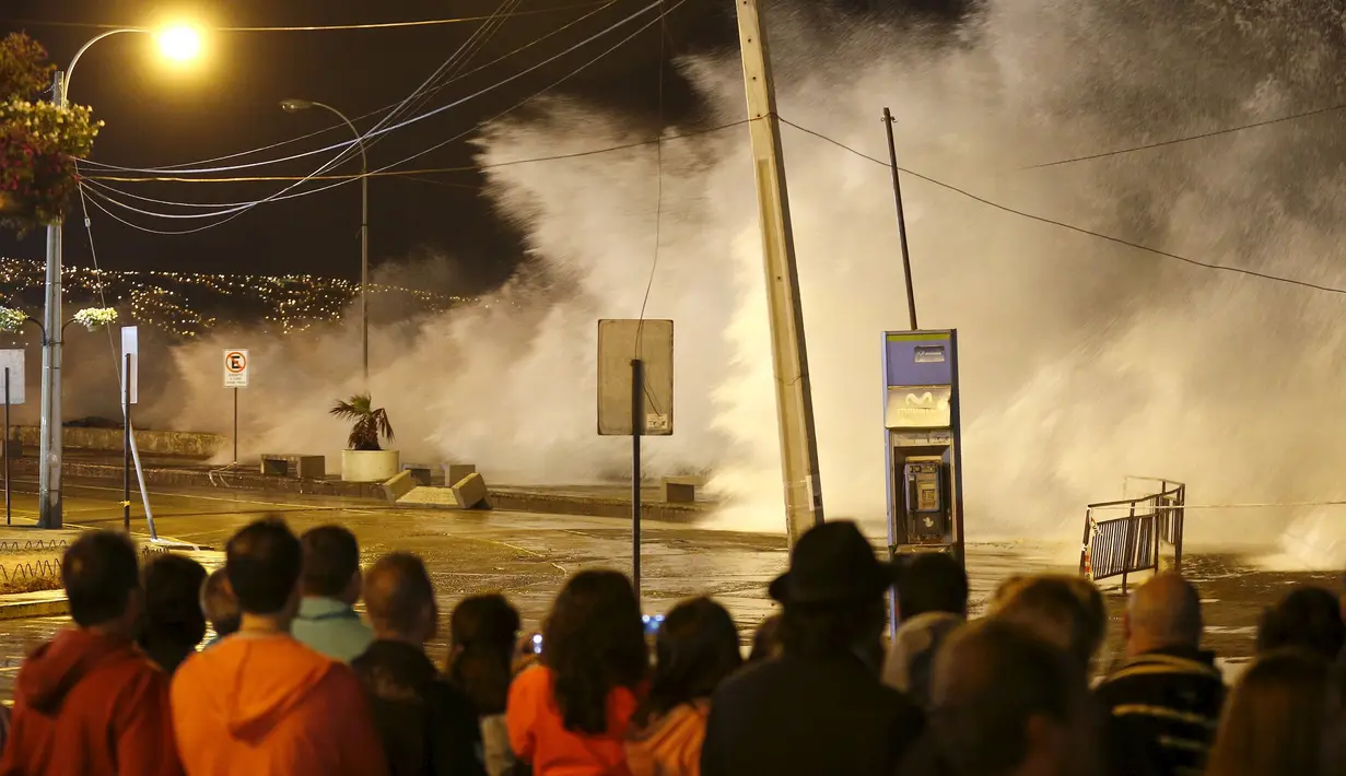 Sejumlah turis asik menonton ombak yang tinggi di pantai kota Vina del Mar, Chile,  (25/1).  Wisatawan sudah di himbau untuk menjauh dari bibir pantai karena ombak dan angin yang tinggi. (REUTERS / Rodrigo Garrido)