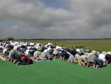 Umat Muslim India bersujud berdoa memohon turun hujan di depan Danau Himayat Sagar di Hyderabad, India, Minggu (21/7/2019). Angin muson yang melanda sejumlah negara bagian India selatan, yang di antaranya, Telangana, Andhra Pradesh dan Tamil Nadu menyebabkan kekeringan parah. (AFP Photo/Noah Seelam)