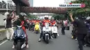Mengenakan jarsey Timnas Indonesia warna merah, Vega ikut bersama para supporter dengan menggunakan motor. [Youtube/Vega Darwanti TV]