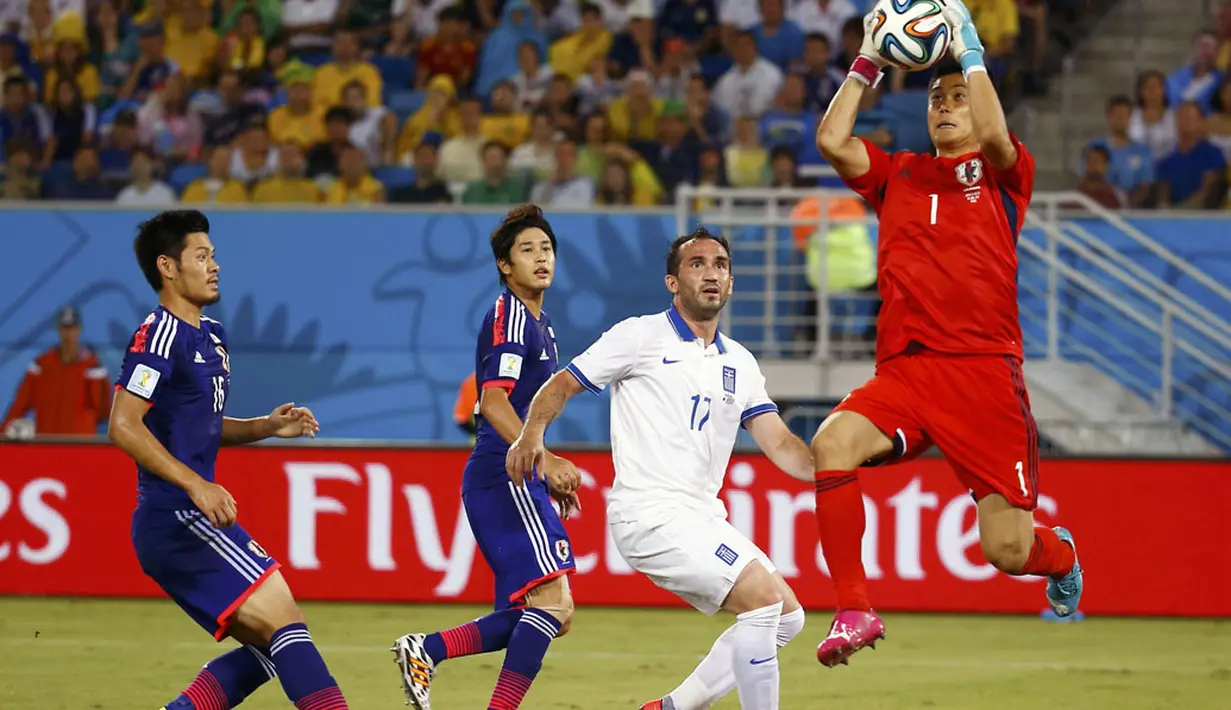 Penjaga gawang Jepang, Eiji Kawashima (kanan), melompat menangkap bola yang mengarah ke Theofanis Gekas dalam laga penyisihan Piala Dunia 2014 Grup C di Stadion Dunas, Natal, Brasil, (20/6/2014). (REUTERS/Kai Pfaffenbach)