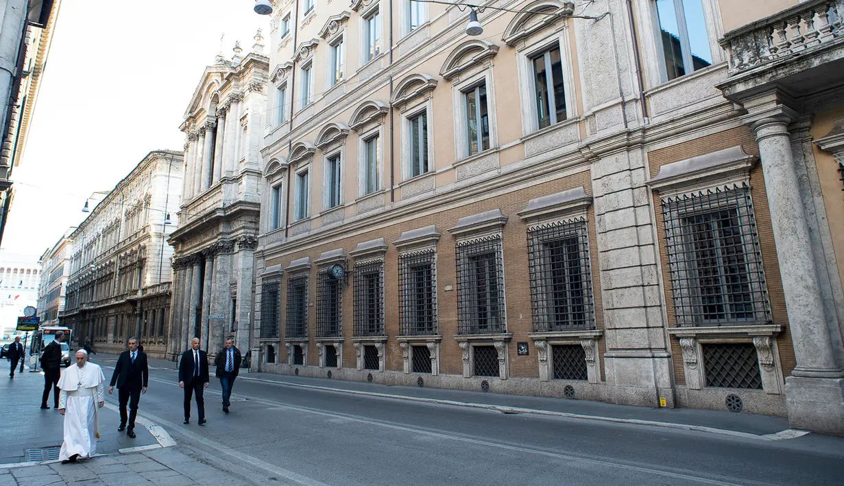 Paus Fransiskus berjalan menuju St. Marcello al Corso di Roma, Italia, Minggu (15/3/2020). Paus menyusuri jalan-jalan Roma yang sepi setelah diberlakukan lockdown untuk mengantisipasi penyebaran virus corona COVID-19. (Vatican News via AP)