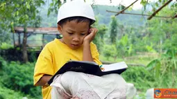 Citizen6, Karawang: Seorang anak kecil sedang mengaji di lingkungan yang asri. (pengirim: Deni Iskandar)