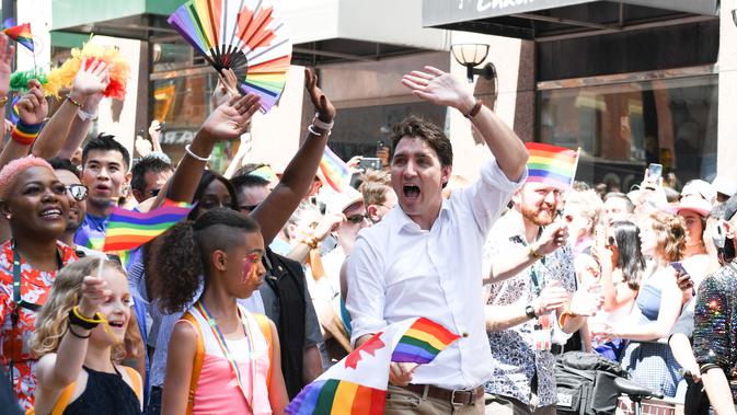 Perdana Menteri Kanada Justin Trudeau menyapa warga saat mengikuti pawai LGBT Toronto's Pride Parade di Toronto, Kanada, Minggu (23/6/2019). Pawai digelar untuk mengenang peristiwa Stonewall yang terjadi di New York pada Juni 1969. (George Pimentel/GETTY IMAGES NORTH AMERICA/AFP)