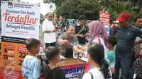 Petugas KPUD DKI Jakarta melayani warga yang mendaftarkan diri di Pos Penyempurnaan Data dan Daftar Pemilih saat pelaksanaan HBKB di Jakarta, Minggu (12/3). (Liputan6.com/Immanuel Antonius)