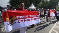 Seorang peserta membentangkan spanduk saat mengikuti aksi Parade Bhineka Tunggal Ika di kawasan Patung Kuda di Jalan MH Thamrin, Jakarta Pusat, Sabtu (19/11). Parade tersebut juga bertujuan untuk mempererat persatuan bangsa. (Liputan6.com/Gempur M. Surya)
