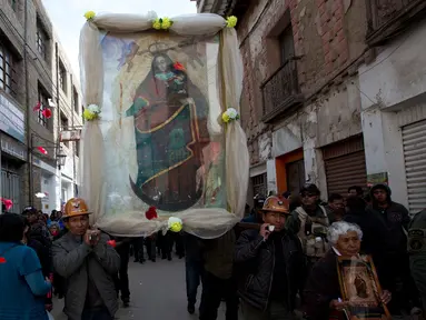 Penambang membawa gambar Our Lady of Socavon dalam sebuah prosesi untuk menghormati santo pelindung mereka, di Oruro, Bolivia (1/3). Ratusan orang yang terdiri dari warga, uskup agung, dan pejabat setempat mengikuti acara ini. (AP Photo/Juan Karita)