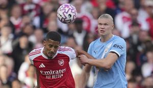 Pemain Arsenal, William Saliba (kiri), berduel dengan striker Man City, Erling Haaland, pada pekan 5 Liga Inggris 2025/2026 di Emirates Stadium, Minggu (21/9/2025) malam WIB. (AP Photo/Kin Cheung)