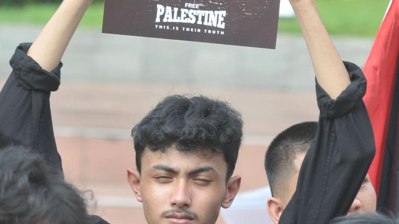 Seorang pengunjuk rasa mengangkat poster saat menggelar aksi solidaritas untuk Palestina di Tugu Proklamasi, Jakarta, Sabtu (15/6/2024).&nbsp;Merdeka.com/Imam Buhori