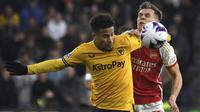 Gelandang Wolverhampton Wanderers, Joao Gomes (kiri) berebut bola dengan gelandang Arsenal, Leandro Trossard pada laga pekan ke-33 Premier League 2023/2024 di Molineux Stadium, Wolverhampton, Sabtu (20/4/2024). (AP Photo/Rui Vieira)