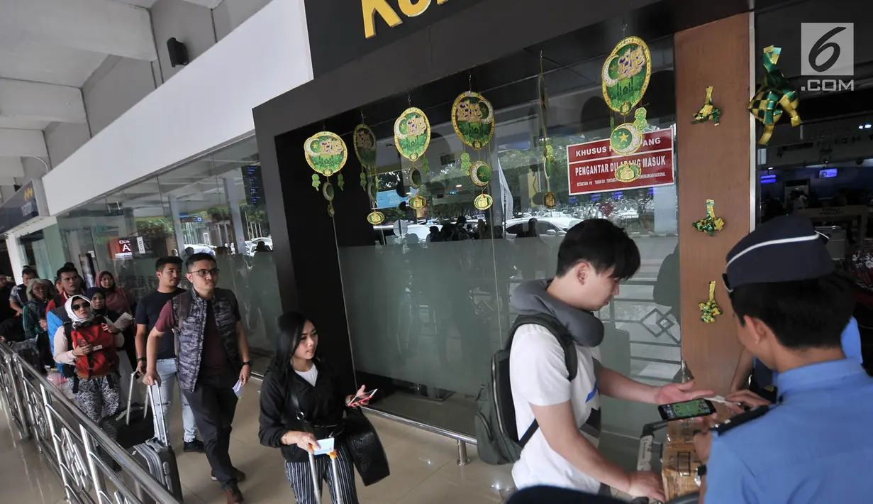 Petugas memeriksa tiket di pintu keberangkatan Bandara Halim Perdanakusuma, Jakarta, Senin (11/6). Untuk mengatasi lonjakan penumpang, 3 maskapai penerbangan di Bandara Halim menambahkan 12 slot penerbangan ekstra. (Liputan6.com/Iqbal S. Nugroho)