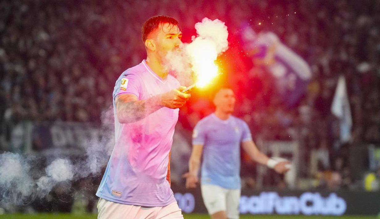 Pemain Lazio, Alessio Romagnoli, membuang flare yang masuk ke lapangan saat melawan AS Roma pada laga perempat final Coppa Italia 2023/2024 di Stadio Olimpico, Kamis (11/1/2024). (AP Photo/Gregorio Borgia)