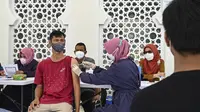 Seorang pria menerima dosis vaksin virus corona COVID-19 Sinovac saat pelaksanaan vaksinasi di Masjid Raya Baiturrahman, Banda Aceh, Aceh, Selasa (7/9/2021). (CHAIDEER MAHYUDDIN/AFP)