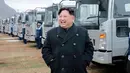Pemimpin Korea Utara, Kim Jong-Un tersenyum saat mengecek sejumlah truk keluaran terbaru di Kompleks Motor Sungri di Provinsi Pyongan Selatan (21/11). (Kcna Via Kns/AFP)