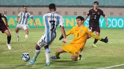 Kiper Timnas Venezuela U-17, Jorge Sanchez, berusaha menghalau tendangan dari pemain Timnas Argentina U-17, Octavio&nbsp;Ontivero, pada laga 16 besar Piala Dunia U-17 2023 di Stadion Si Jalak Harupat, Bandung, Selasa (21/11/2023). (Bola.com/Ikhwan Yanuar)