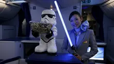 Seorang Pramugari menyapa pengunjung sambil memegang lightsabre atau pedang laser di pesawat Boeing 787 Dreamliner, Singapura, Kamis (12/11/2015).  Pesawat bertema Star Wars ini menjadi pertama di Asia Tenggara. (REUTERS/Edgar Su)