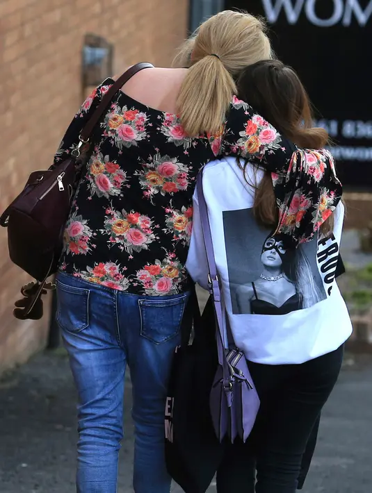 Seorang penggemar Ariana Grande meninggalkan hotel Park Inn usai ledakan yang terjadi saat konser Ariana Grande di Manchester, Inggris (23/5). Kepolisian memastikan sedikitnya 19 orang tewas dan 50 lainnya terluka dalam ledakan itu. (AP Photo/Rui Vieira)