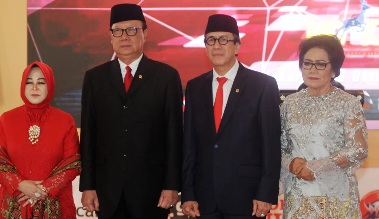 Yasonna Laoly (kedua kanan) beserta istrinya Elisye Widya Ketaren (kanan) foto bersama Tjahjo Kumolo (kedua kiri) beserta istrinya Erni Guntarti saat serah terima jabatan Menteri Hukum dan Hak Asasi Manusia (Menkumham) di Jakarta, Rabu (23/10/2019). (merdeka.com/Dwi Narwoko)