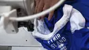Seorang pekerja menjahit seragam timnas Islandia di Torrile, dekat Parma, Italia Utara, (20/4). Seragam timnas Islandia ini merupakan rancangan perusahaan apparel olahraga asal Italia. (AFP Photo/Marco Bertorello)