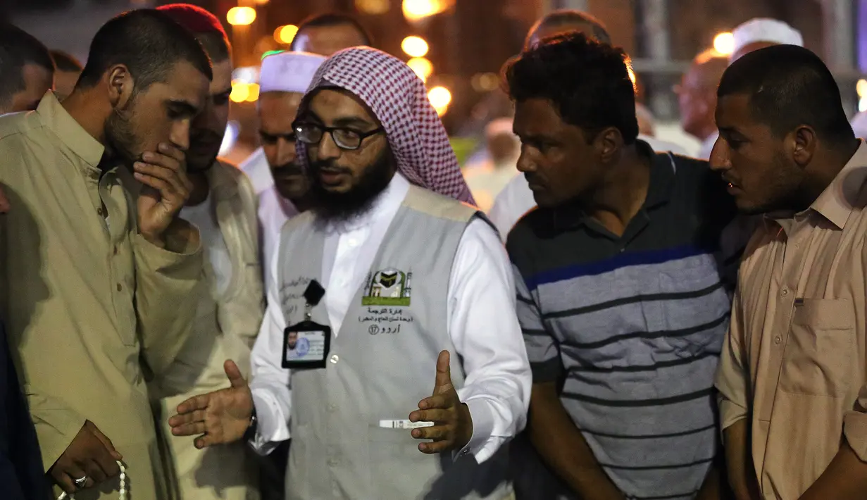 Jemaah haji berbincang dengan seorang penerjemah di kota suci Islam, Makkah, 17 Agustus 2018. Pemerintah Arab Saudi mengerahkan para penerjemah dari berbagai bahasa yang bekerja 24 jam per hari untuk membantu para jemaah. (AFP/AHMAD AL-RUBAYE)