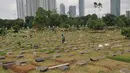 Pekerja membersihkan area makam di TPU Karet Bivak, Jakarta (2/2). Dinas Pertamanan dan Pemakaman telah menerapkan sistem online dalam pelayanan pemakaman di Ibu kota dengan alamat situs pertamananpemakaman.jakarta.go.id. (Liputan6.com/Gempur M Surya)