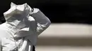 Embusan angin menyebabkan wajah Paus Fransiskus tertutup jubahnya sendiri saat memberkati umat setelah misa pada pertemuan dengan para pemuda di Lapangan Santo Petrus, Vatikan, Minggu (12/8). (AFP PHOTO / FILIPPO MONTEFORTE)