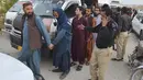 Polisi tiba bersama imigran Afghanistan yang ditahan di pusat deportasi, yang didirikan oleh pihak berwenang untuk memfasilitasi imigran ilegal, di Quetta, Pakistan, Rabu (1/11/2023). (AP Photo/Arshad Butt)