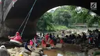 Seorang anak bermain ayunan di kolong jembatan Sempur, Bogor (16/9). Musim kemarau yang menyebabkan debit Sungai Ciliwung menyusut drastis dimanfaatkan warga Bogor dan sekitarnya untuk berwisata murah dan gratis di aliran sungai. (Merdeka.com/Arie Basuki)