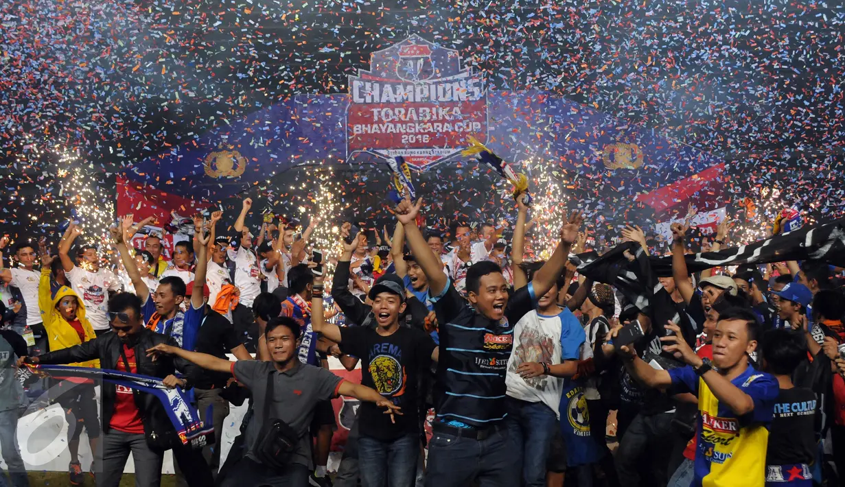 Suporter Arema Cronus berlarian merayakan kemenangan tim Singo Edan di laga final Piala Bhayangkara 2016 melawan Persib di Stadion GBK Jakarta, Minggu (3/4/2016). Arema Cronus unggul 2-0 atas Persib. (Liputan6.com/Helmi Fithriansyah)