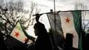Seorang pria mengibarkan bendera oposisi saat anggota komunitas dan pendukung Suriah berkumpul untuk merayakan kejatuhan Presiden Suriah Bashar al-Assad, di distrik Fatih, Istanbul, 8 Desember 2024. (KEMAL ASLAN/AFP)