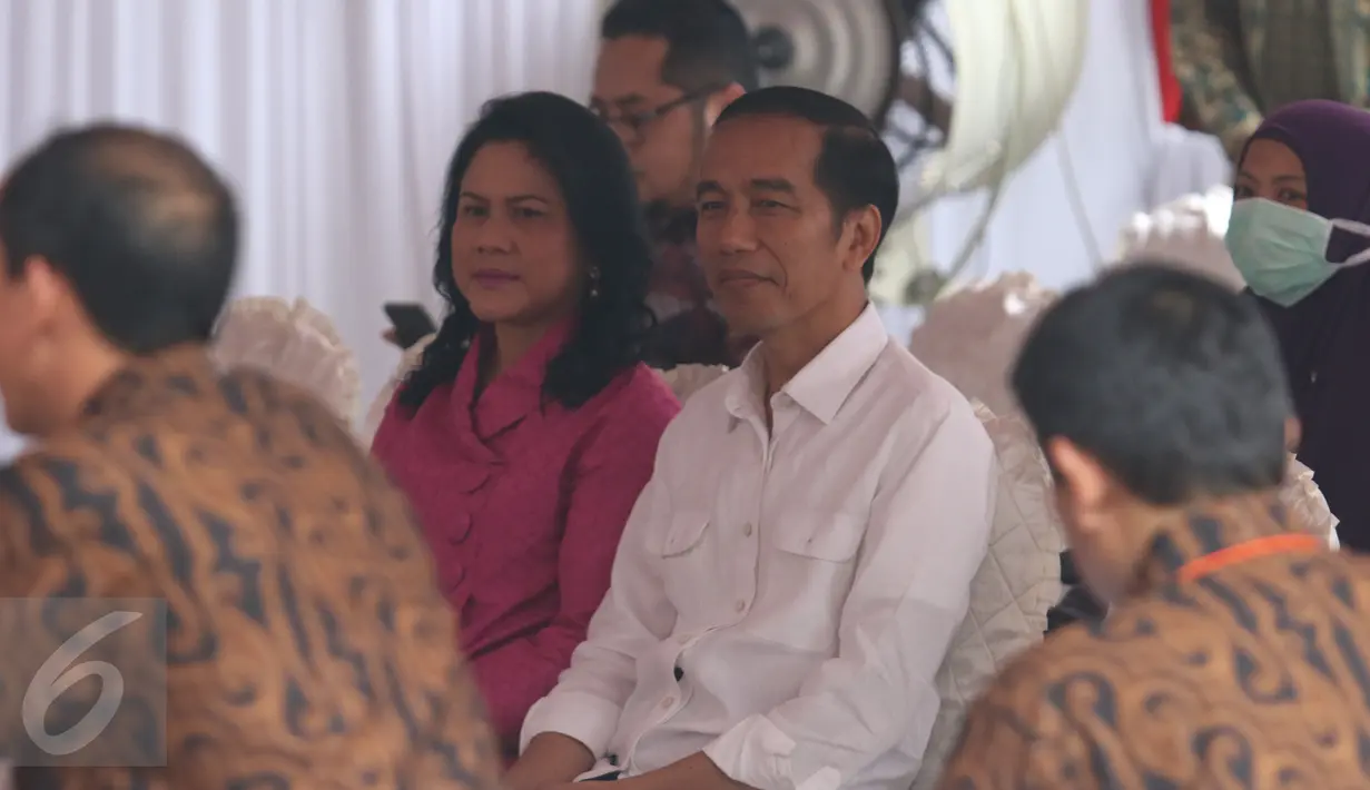 Presiden Jokowi didampingi Ibu Negara, Iriana, mengantre sebelum menyalurkan hak pilihnya pada Pilkada DKI 2017 di TPS 04 Gambir, Jakarta, Rabu (19/4). Jokowi terdaftar dalam DPT nomor 218, sedangkan Iriana di DPT nomor 219. (Liputan6.com/Angga Yuniar)