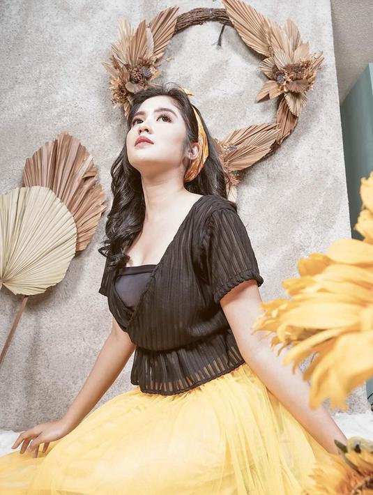 Perpaduan warna hitam dan kuning memang perpaduan yang manis. Penampilan Ochi dalam balutan crop top hitam dipadukan dengan skirt kuning membuat tampilannya lebih fresh dan ceria. Bandana kuning membuat, gaya Ochi semakin chic dan fashionable. (Liputan6.com/IG/@ochi24)