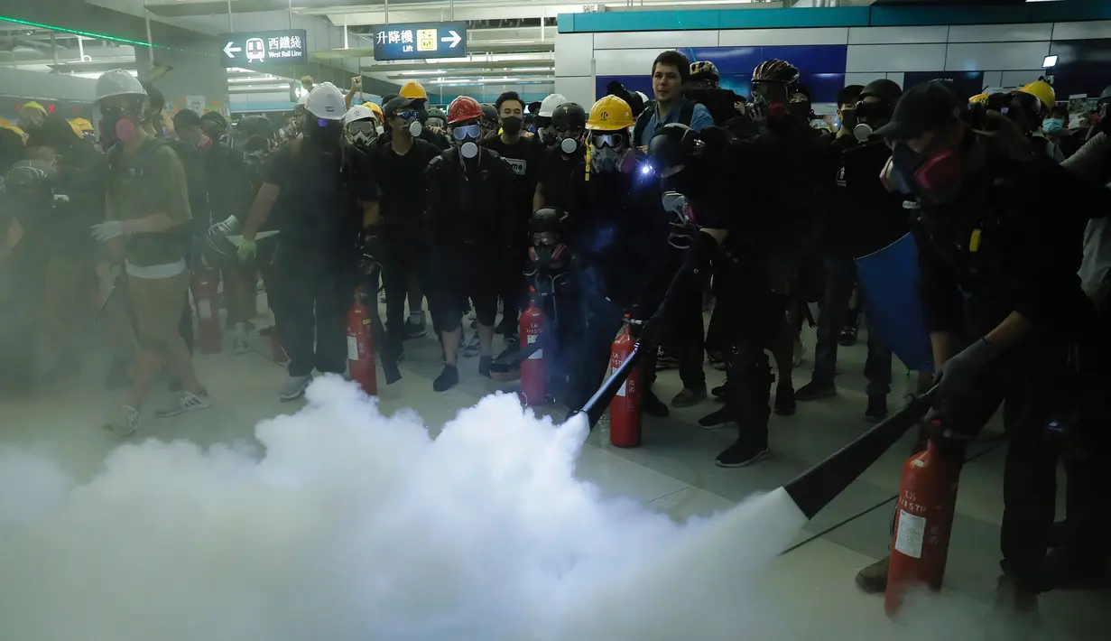 Demonstran menyemprotkan alat pemadam kebakaran saat berunjuk rasa di Stasiun MTR Yuen Long, Hong Kong, Rabu (21/8/2019). Unjuk rasa ini bentuk kemarahan karena pada 21 Juli lalu terjadi penyerangan di sini dan tak ada satu terduga pelaku pun yang diproses secara hukum. (AP Photo/Kin Cheung)