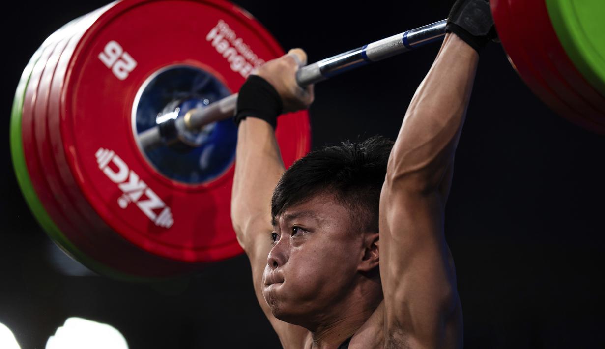 Lifter putra Indonesia, Rahmat Erwin Abdullah, melakukan angkatan snatch pada final 73 kilogram Grup A Asian Games 2022 di Xiaoshan Sports Centre Gymnasium, Hangzhou, China, Selasa (3/10/2023). Rahmat Erwin meraih medali emas dengan total angkatan 359 kilogram sekaligus memecahkan rekor Asian Games. (AP Photo/Louise Delmotte)