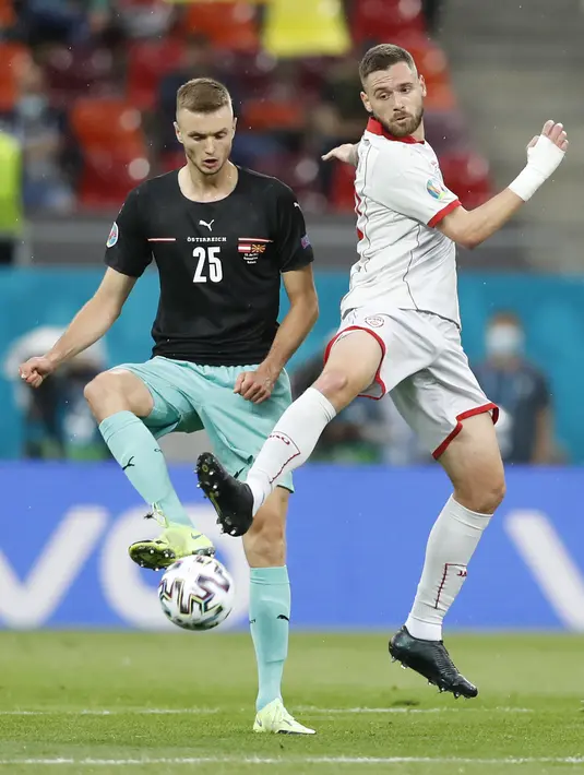 Penyerang Makedonia Utara, Aleksandar Trajkovski berebut bola dengan pemain Austria, Sasa Kalajdzic pada pertandingan grup C Euro 2020 di stadion National Arena di Bucharest, Rumania, Minggu (13/6/2021). Austria menang atas Makedonia Utara dengan skor 3-1. (AP Photo/Vadim Ghirda, Pool)